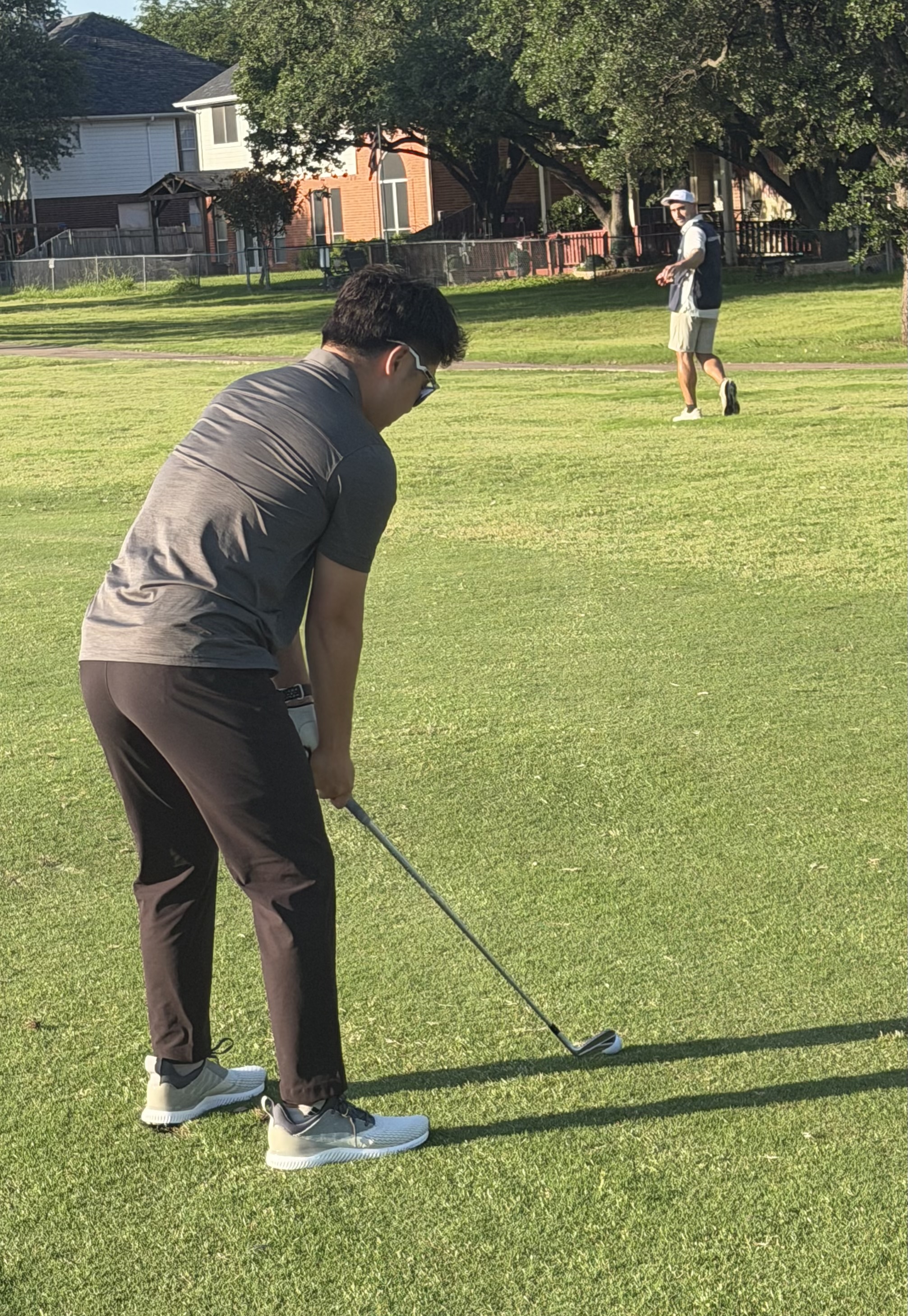 Spotter walking ahead of a golfer at address